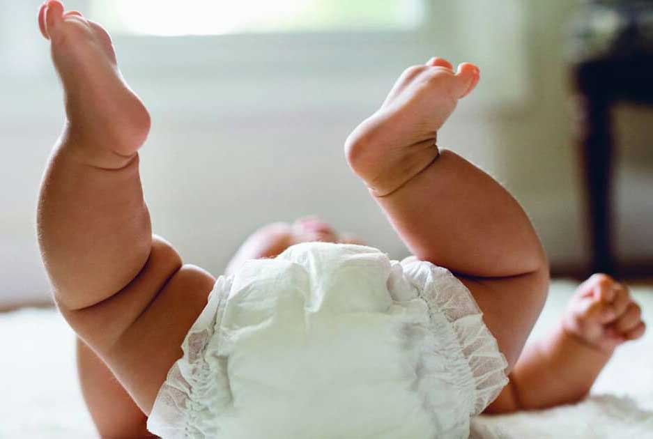 Baby lying on its back wearing a nappy