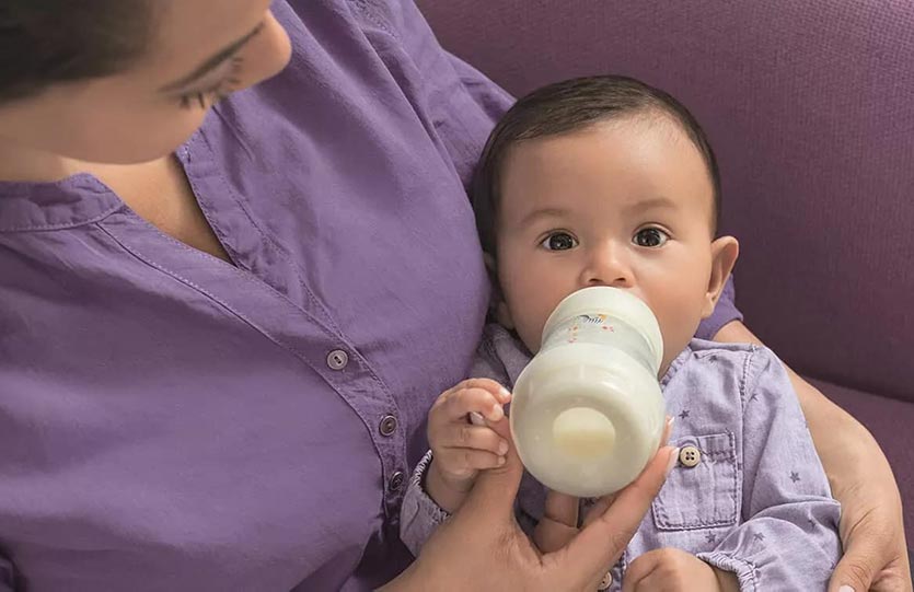 Parent bottle-feeding a baby at home