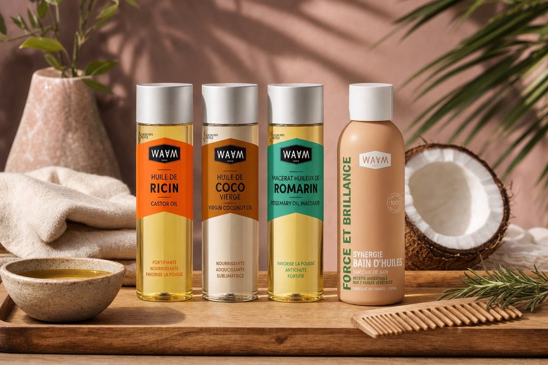 Bottles of WAAM coconut, castor and argan oil beside a comb and a section of dark hair, ready for a pre-shampoo oil bath