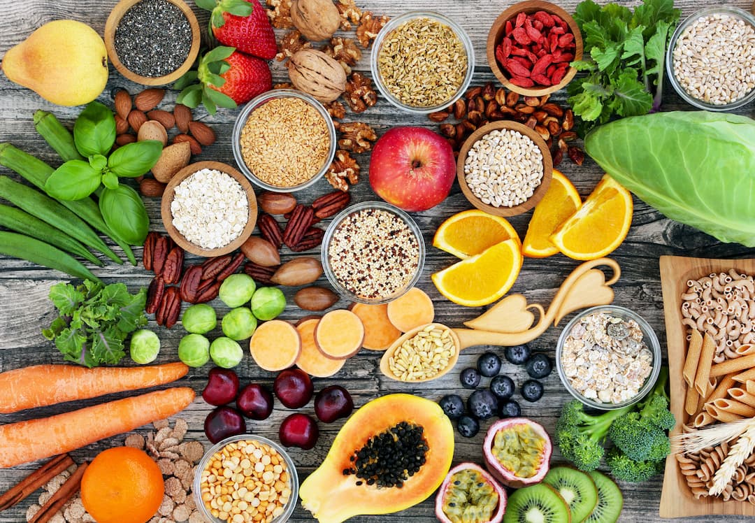 Fresh fruit, vegetables, wholegrains, nuts and seeds arranged on a wooden table — healthy and natural food in Mauritius